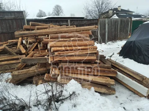 Складированные деревянные бревна после демонтажа дома